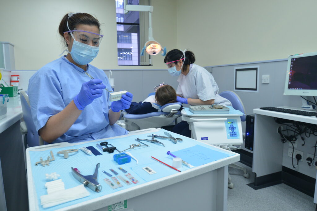 dental team preparing equipment and giving treatment to patient