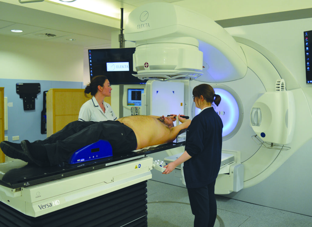 Photograph of radiographers positioning a patient ready for treatment.