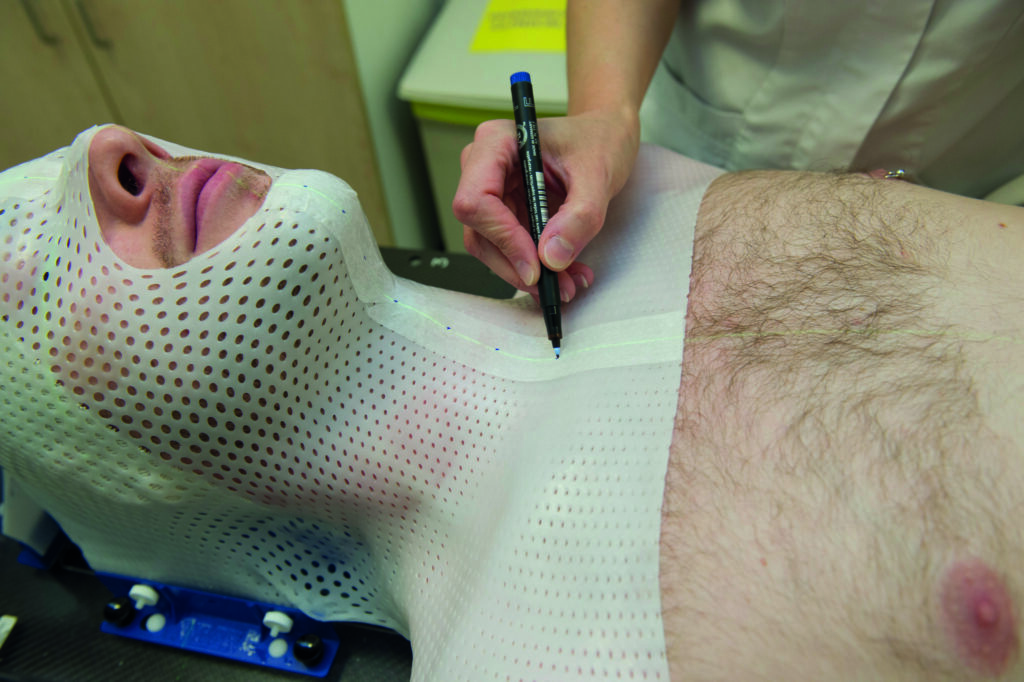 An image of a patient being fitted with a plastic mask.