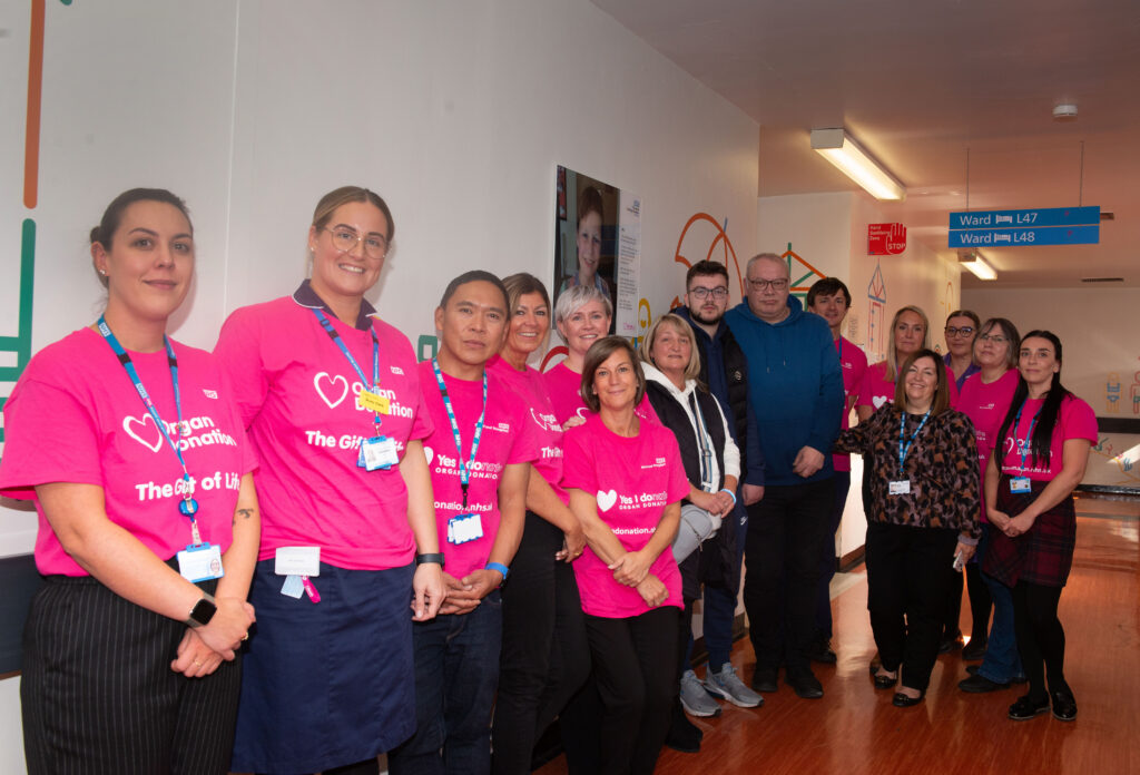 Staff and Family members wearing pink organ donation t-shirts, stood next to the plaque of Alfie been unveiled.