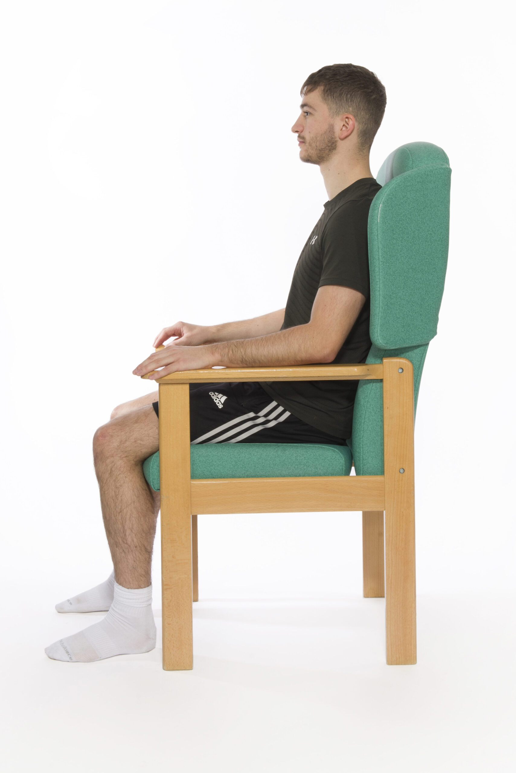 Photograph of a person sat in a chair correctly.