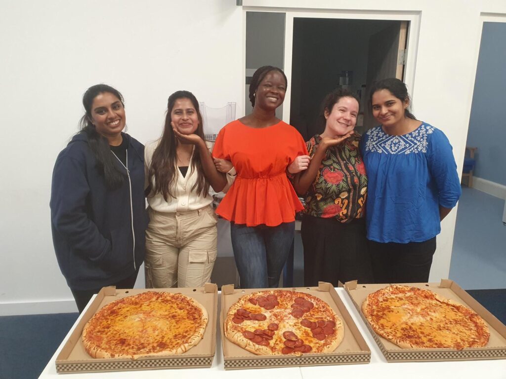 nursing students stood smiling in front of food table