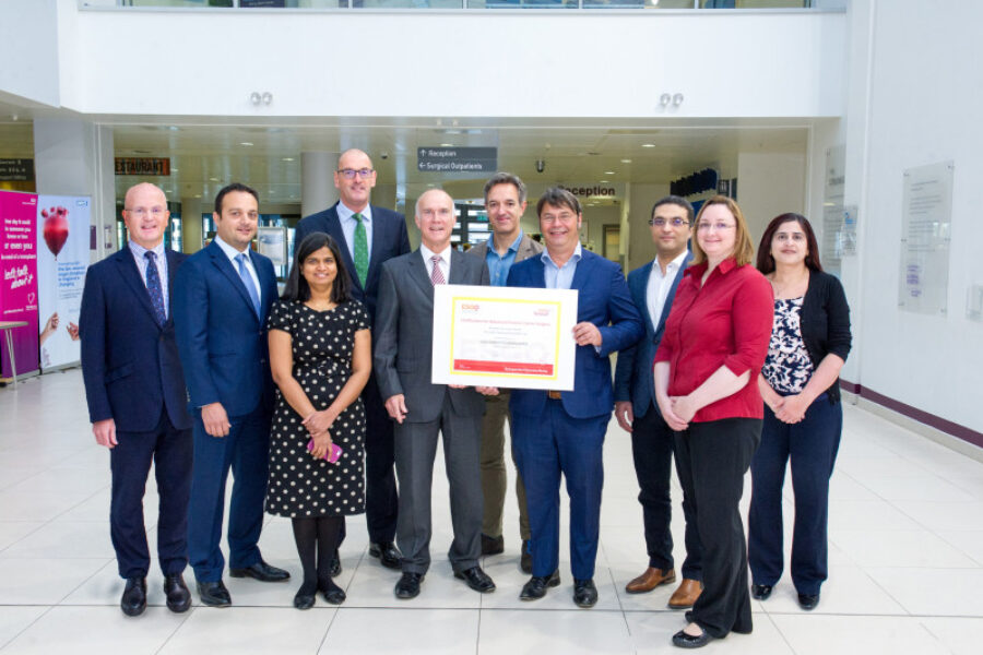 gynae oncology surgical team holding poster smiling in hospital building